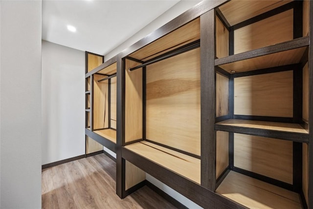 corridor with wood finished floors and baseboards