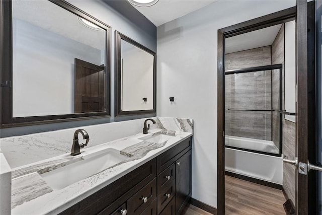 2261 Creekside Rd, Springville, IA 52336 - bathroom with double vanity, wood finished floors, combined bath / shower with glass door, and baseboards
