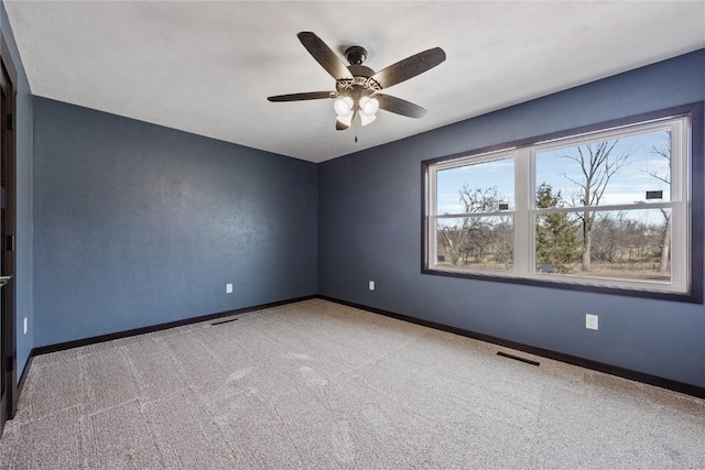 spare room featuring baseboards, carpet floors, visible vents, and ceiling fan