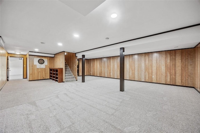 finished below grade area with stairway, recessed lighting, carpet, and wood walls