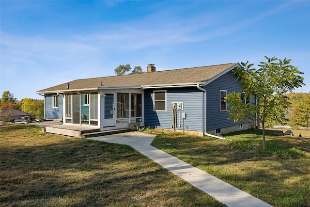 view of front of home featuring a chimney, a front lawn, and a sunroom