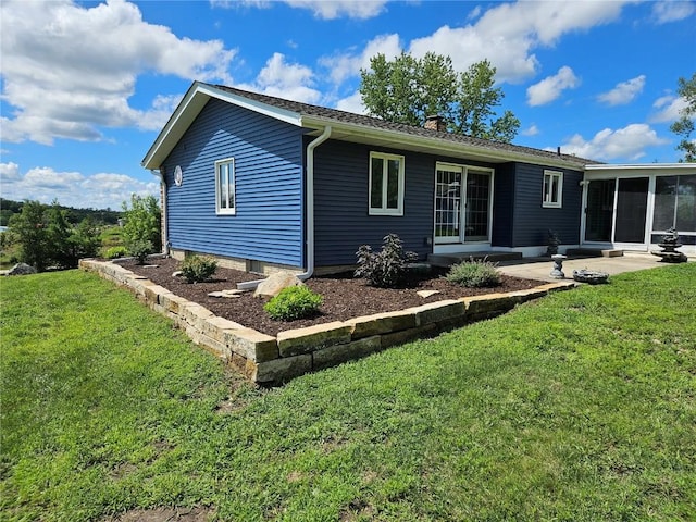 2261 Creekside Rd, Springville, IA 52336 - back of property with a chimney, a sunroom, a lawn, and a patio area