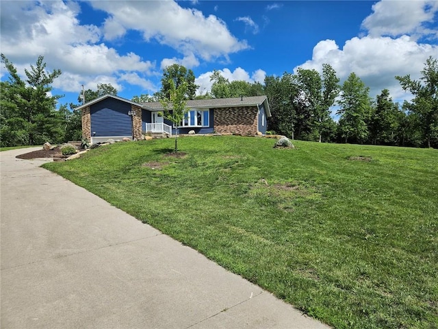 ranch-style house with driveway, an attached garage, and a front lawn