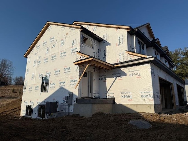 exterior space with central air condition unit, a garage, and stucco siding