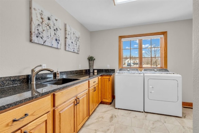 laundry room with washing machine and clothes dryer, marble finish floor, cabinet space, and a sink