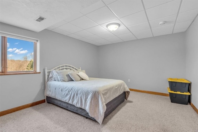 bedroom featuring a drop ceiling, baseboards, visible vents, and carpet floors