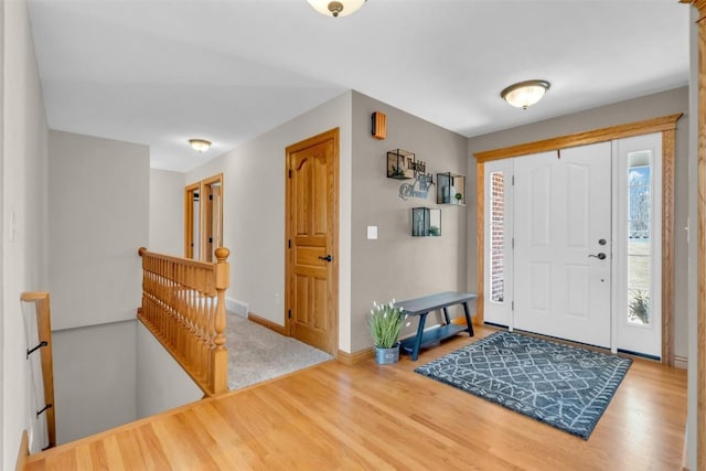 foyer featuring visible vents, baseboards, a healthy amount of sunlight, and wood finished floors