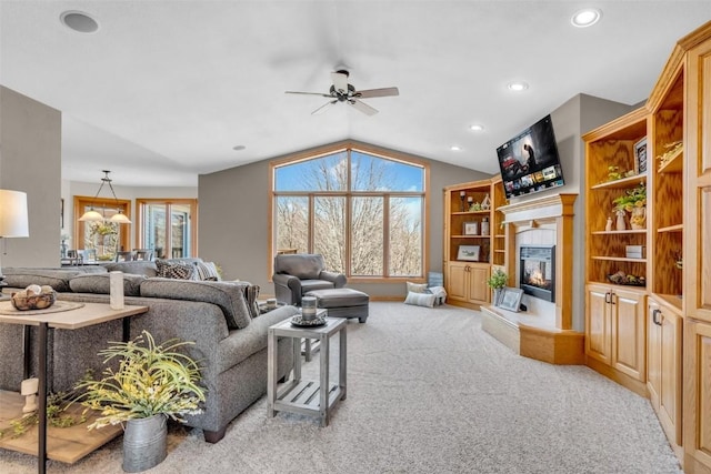 living room with carpet, a ceiling fan, lofted ceiling, recessed lighting, and a glass covered fireplace