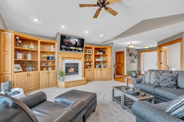 living room featuring ceiling fan, lofted ceiling, light carpet, recessed lighting, and a glass covered fireplace