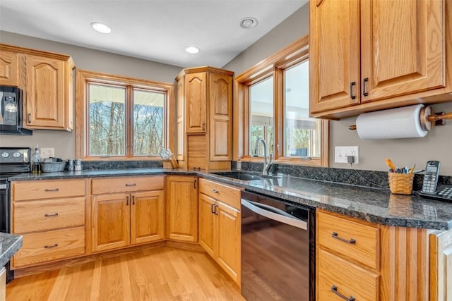 kitchen featuring a sink, light wood-style floors, black appliances, and a healthy amount of sunlight