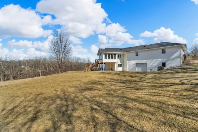 back of house featuring stairway and a lawn