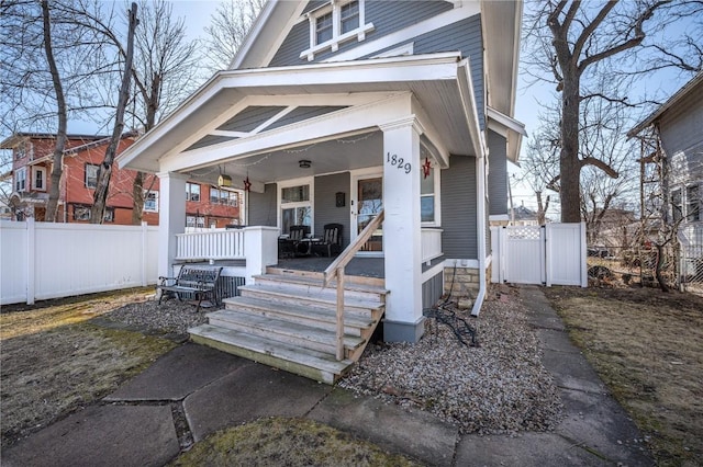 view of front of house featuring fence and covered porch