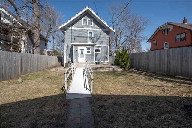 back of house with a yard and a fenced backyard