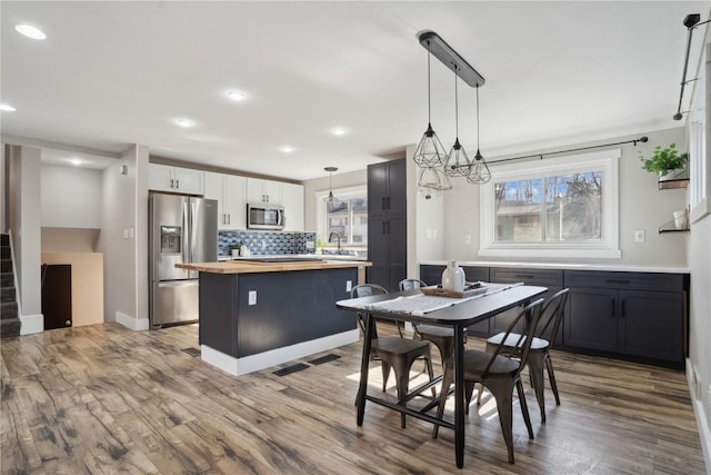 dining area with plenty of natural light, wood finished floors, and visible vents