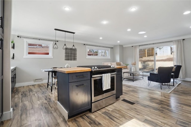 kitchen with wood finished floors, gas stove, visible vents, recessed lighting, and wood counters