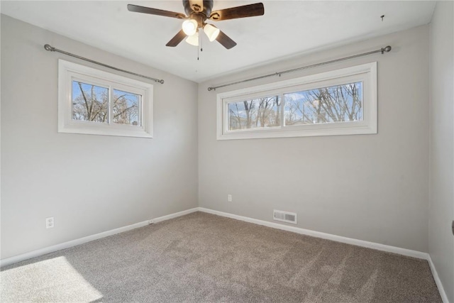 spare room with carpet flooring, baseboards, visible vents, and ceiling fan