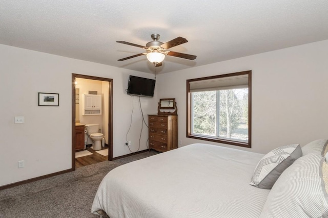 bedroom featuring dark colored carpet, connected bathroom, baseboards, and a ceiling fan