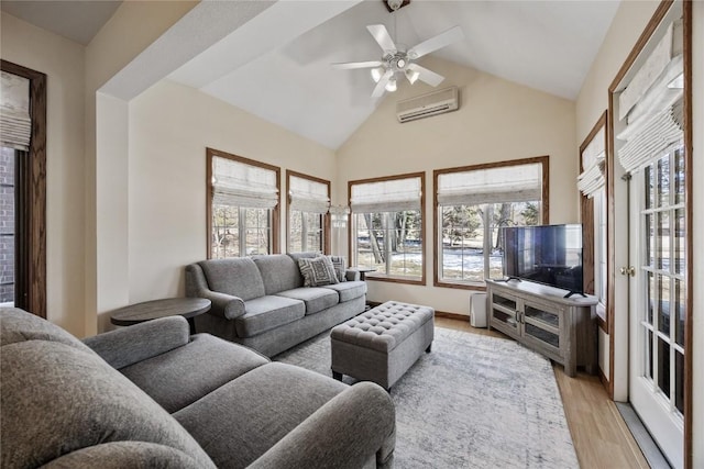 living area featuring a wall mounted air conditioner, a healthy amount of sunlight, ceiling fan, and light wood finished floors