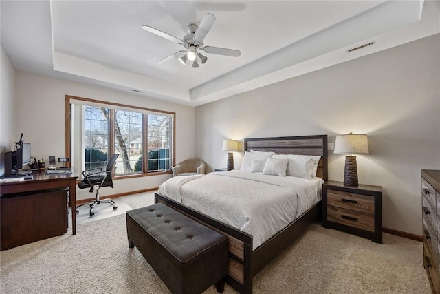 bedroom featuring visible vents, light carpet, a raised ceiling, baseboards, and ceiling fan