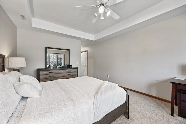 bedroom with visible vents, carpet, baseboards, a raised ceiling, and a ceiling fan