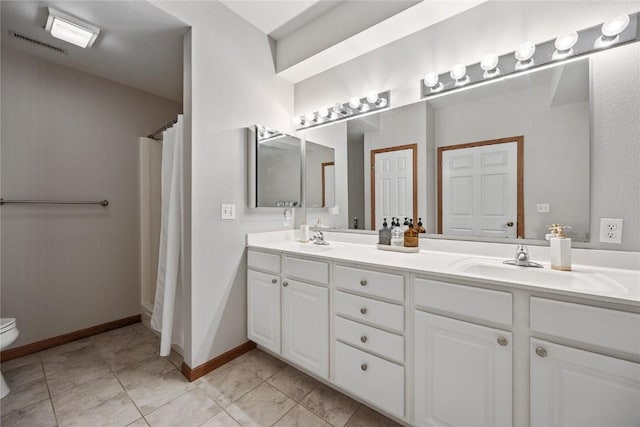 bathroom featuring double vanity, toilet, visible vents, and a sink