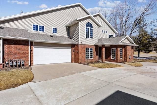 view of front facade featuring concrete driveway and brick siding