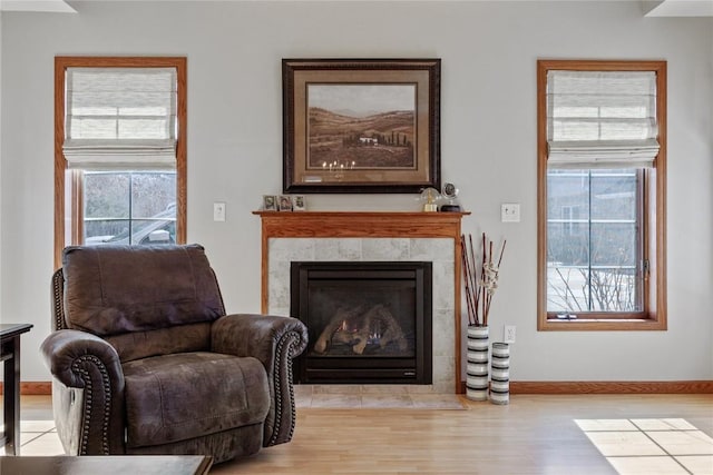 living area featuring a fireplace, wood finished floors, and baseboards