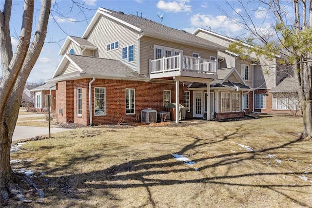 rear view of house with brick siding, central AC, a shingled roof, and a balcony