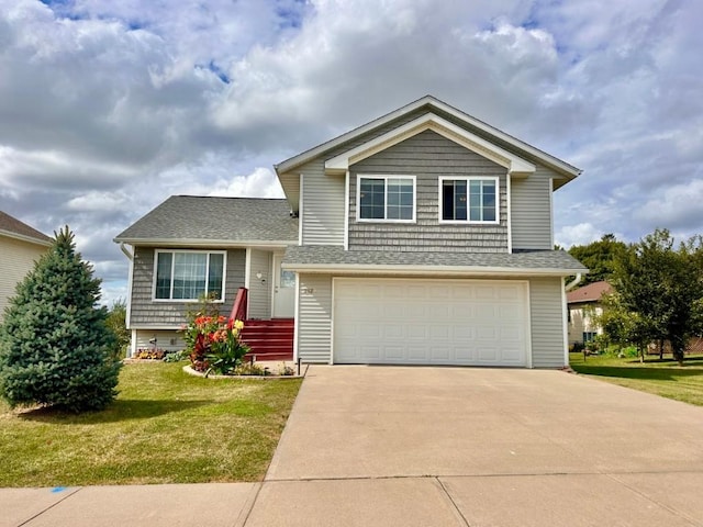 tri-level home with a front yard, concrete driveway, a garage, and roof with shingles