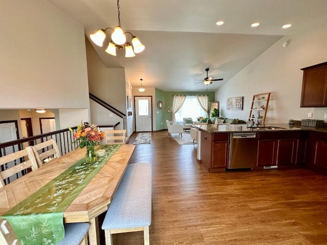 dining area with wood finished floors, high vaulted ceiling, recessed lighting, stairs, and ceiling fan with notable chandelier