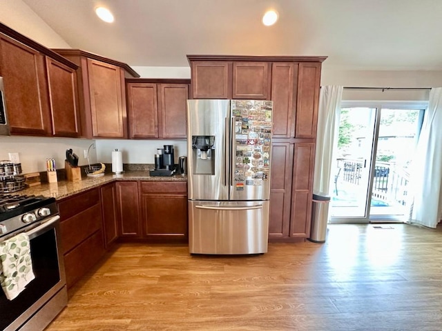 kitchen with dark stone counters, recessed lighting, light wood-style floors, and stainless steel appliances