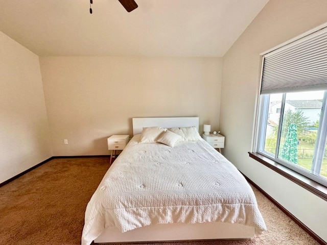 bedroom with lofted ceiling, carpet flooring, baseboards, and ceiling fan