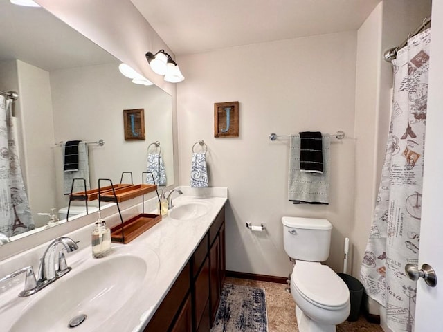 full bath with double vanity, toilet, baseboards, and a sink