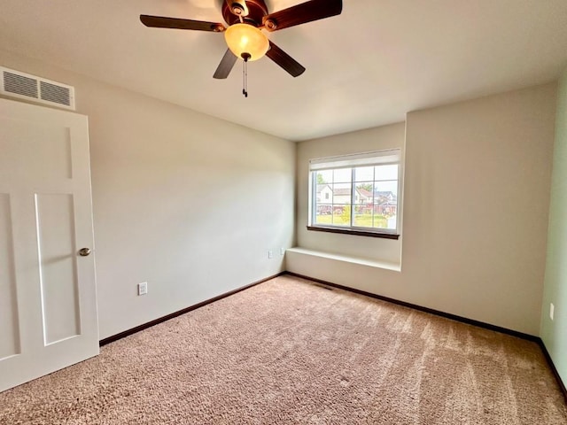 unfurnished room with visible vents, baseboards, carpet, and a ceiling fan