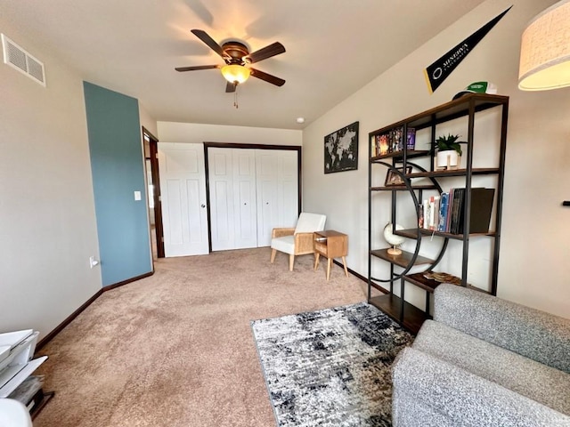 living area with a ceiling fan, visible vents, carpet floors, and baseboards