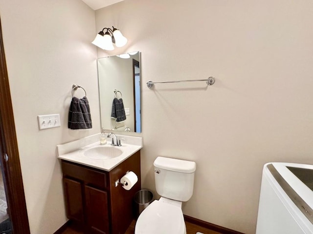 bathroom featuring toilet, vanity, and baseboards