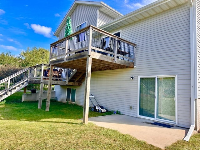 rear view of property with a yard, a deck, stairs, and a patio area