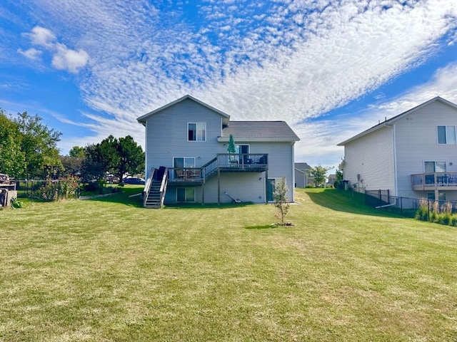 back of property featuring stairway, a yard, fence, and a wooden deck