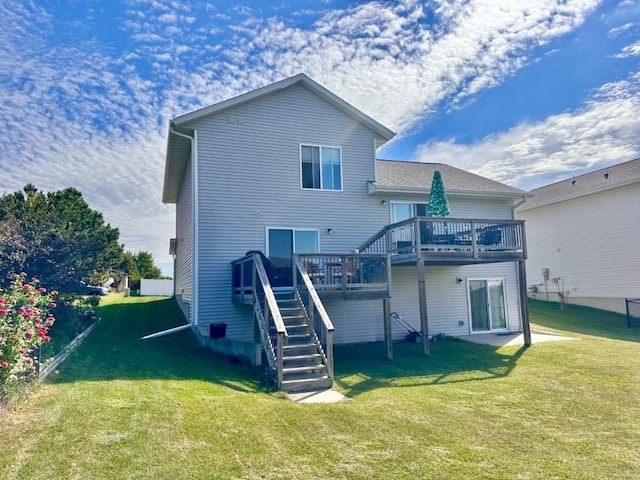 rear view of house featuring stairway, a lawn, and a wooden deck