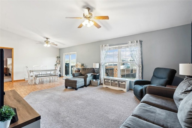 living area featuring baseboards and ceiling fan