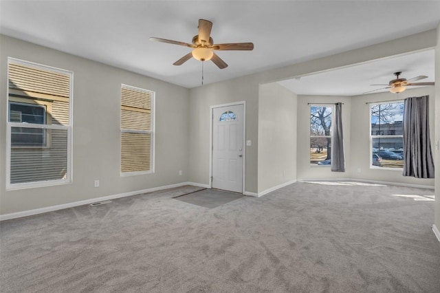 interior space with baseboards, carpet floors, and ceiling fan