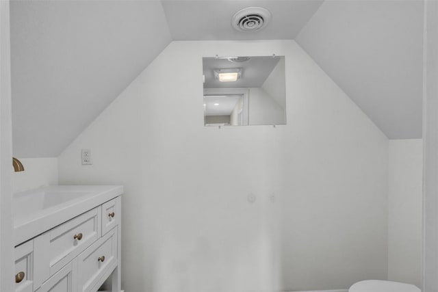 bathroom featuring visible vents, vanity, and vaulted ceiling