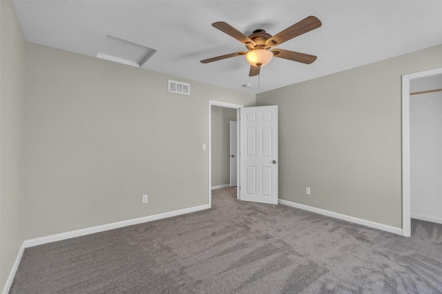 unfurnished bedroom featuring visible vents, baseboards, attic access, carpet floors, and a closet