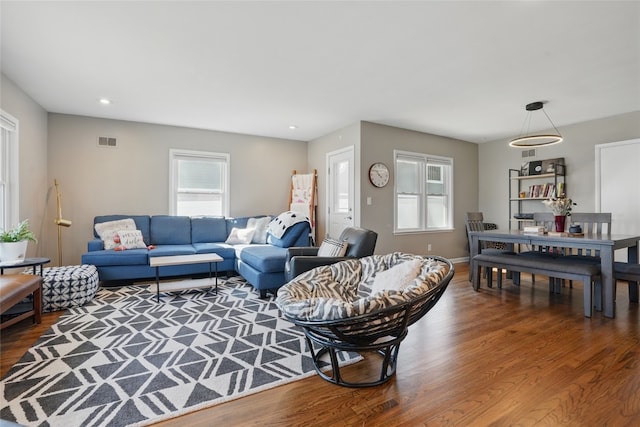 living area with recessed lighting, visible vents, baseboards, and wood finished floors