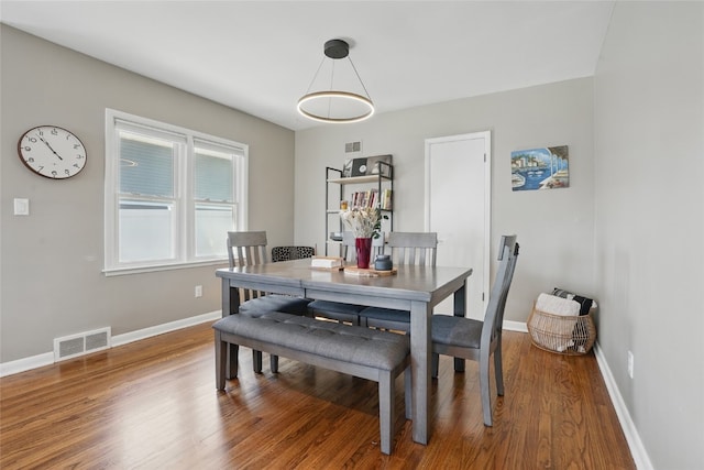 dining area featuring visible vents, baseboards, and wood finished floors