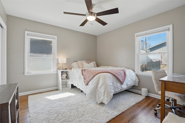 bedroom with a ceiling fan, dark wood-type flooring, and baseboards