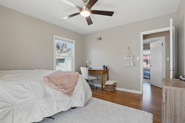 bedroom featuring visible vents, ceiling fan, baseboards, and wood finished floors