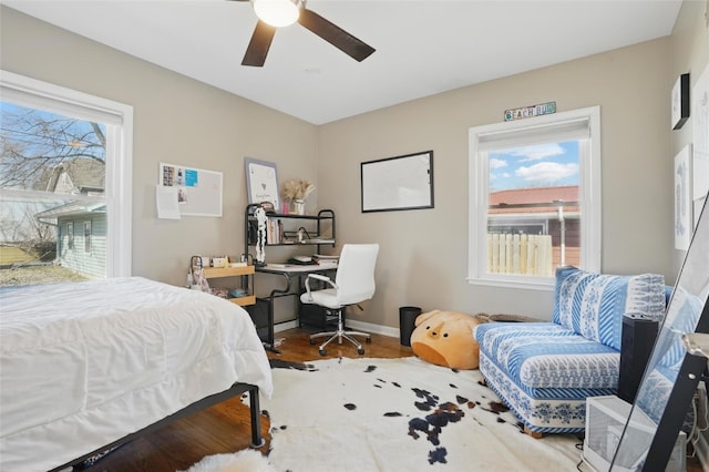 bedroom featuring multiple windows, a ceiling fan, and baseboards