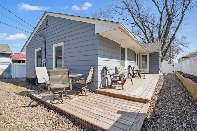 exterior space featuring outdoor dining space, a wooden deck, and a fenced backyard