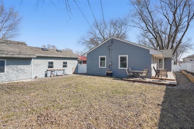 back of property featuring a yard and fence